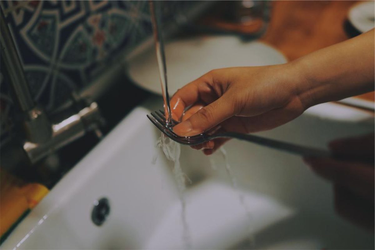 Hands washing up at a kitchen sink