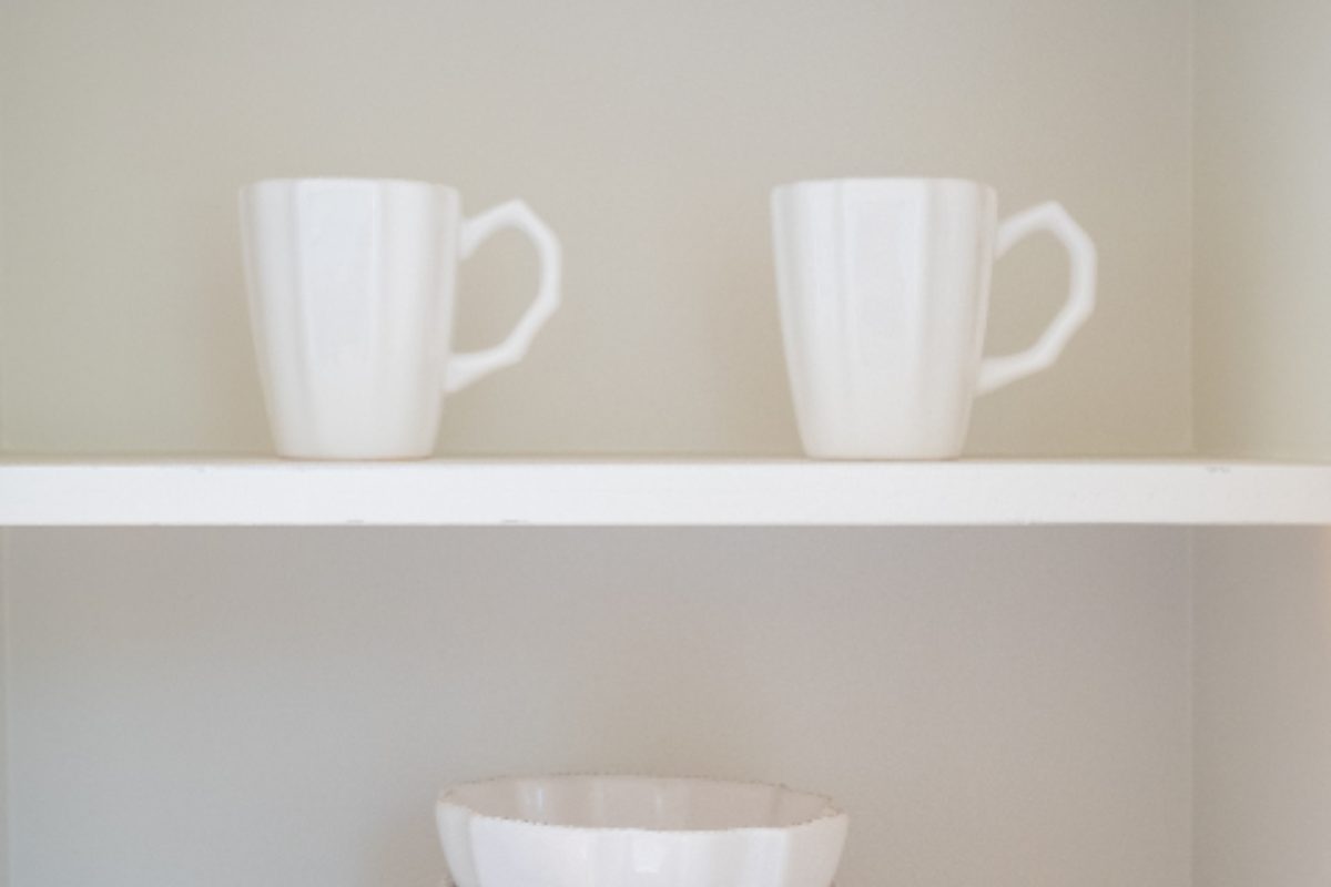 Neatly stacked cups and bowls in a cupboard